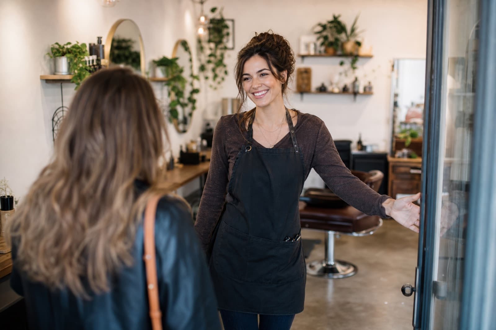 Salon owner welcoming a client into her local shop