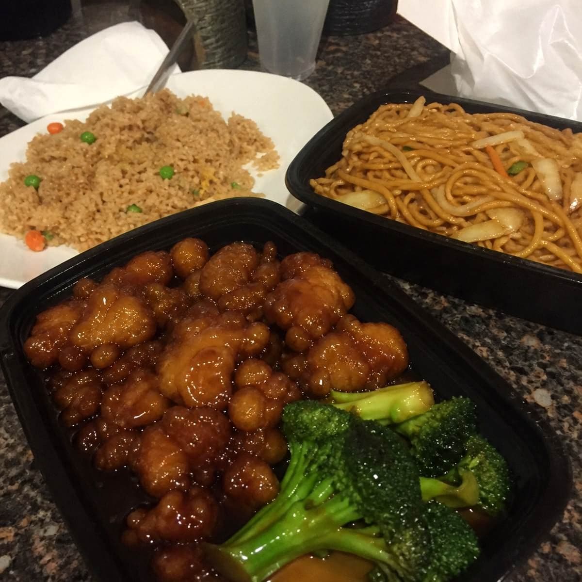 Family-run takeout spot stapling up a bag of to-go containers at the counter