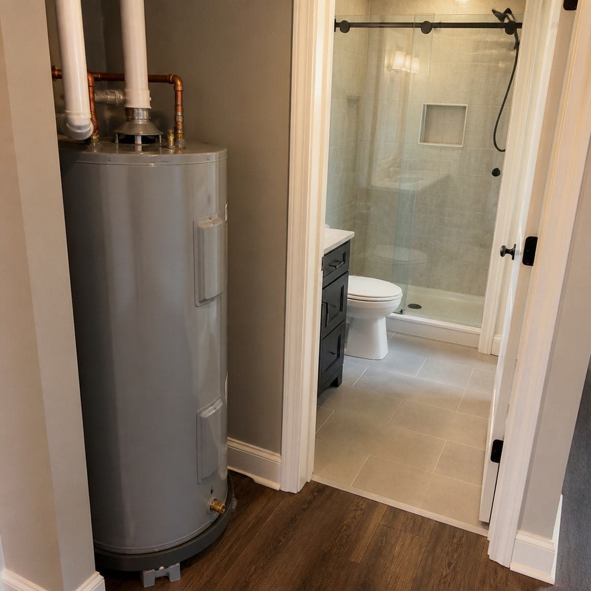 Plumber talking with a homeowner in front of a kitchen sink repair