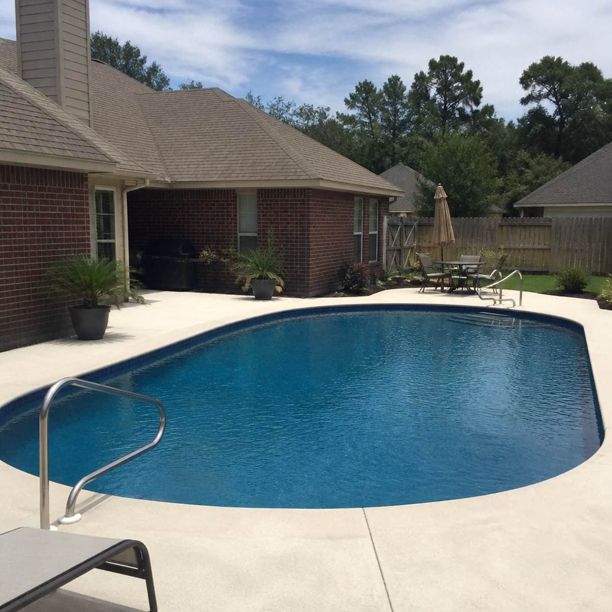 Outdoor living contractor reviewing a completed pool and patio project with a homeowner