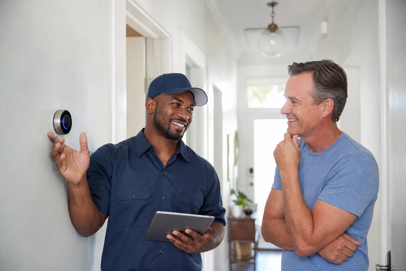 HVAC technician showing a homeowner their new thermostat